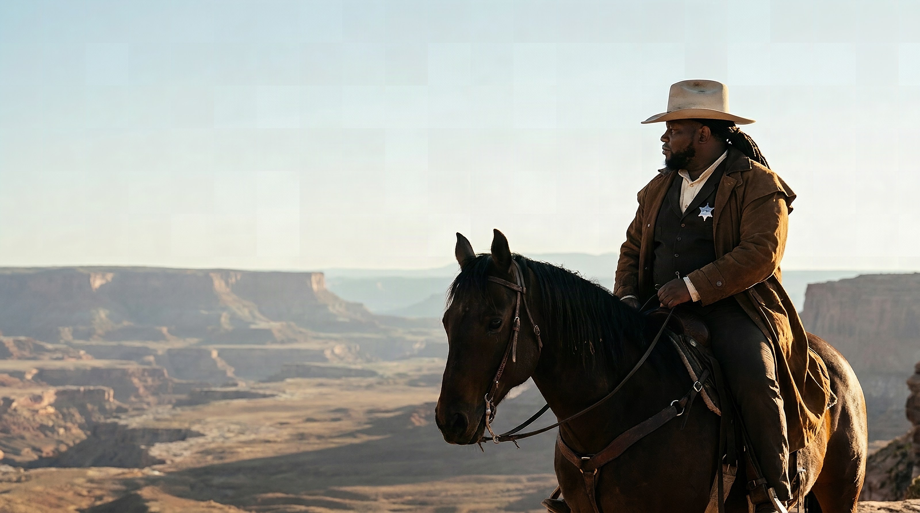 Duncan Daniels as a frontier sheriff on horseback at the rim of a desert canyon at golden hour
